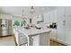 Modern white kitchen with a large island and stainless steel appliances at 676 Key Royale Drive, Holmes Beach, FL 34217