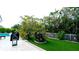 Landscaped backyard with tropical plants and a white picket fence at 676 Key Royale Drive, Holmes Beach, FL 34217