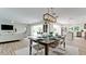 Open concept dining area with modern light fixture, adjacent to kitchen and living room at 676 Key Royale Drive, Holmes Beach, FL 34217
