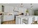 Modern white kitchen with stainless steel appliances and quartz countertops at 676 Key Royale Drive, Holmes Beach, FL 34217