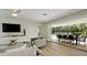 Living room with large TV and sliding glass doors to backyard and pool at 676 Key Royale Drive, Holmes Beach, FL 34217