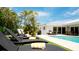Luxury pool area with multiple lounge chairs and lush landscaping at 676 Key Royale Drive, Holmes Beach, FL 34217