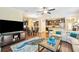 Open concept living room with hardwood floors, sectional sofa, and large TV at 27855 Arrowhead Cir, Punta Gorda, FL 33982