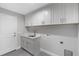 Bright laundry room with white cabinets and a utility sink at 214 Lime Tree Park, Rotonda West, FL 33947