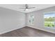 Well-lit bedroom with two windows and grey wood-look floors at 214 Lime Tree Park, Rotonda West, FL 33947