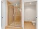 Bathroom featuring a glass-enclosed shower and a separate toilet room, with tiled floors and neutral finishes at 611 Riviera Dunes Way # 308, Palmetto, FL 34221
