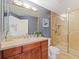 Bathroom featuring a glass-enclosed shower and wood vanity, with tiled floors and neutral finishes at 611 Riviera Dunes Way # 308, Palmetto, FL 34221