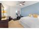Cozy bedroom with ceiling fan, white bedding, blue accent wall, exercise bike and storage at 611 Riviera Dunes Way # 308, Palmetto, FL 34221