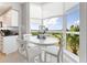 Bright breakfast nook with white table set in front of a window overlooking tropical landscape at 611 Riviera Dunes Way # 308, Palmetto, FL 34221