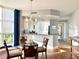 Bright dining room with chandelier, wood floors, and partial kitchen view at 611 Riviera Dunes Way # 308, Palmetto, FL 34221