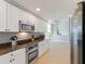 Bright kitchen features modern stainless steel appliances, granite countertops, and white cabinets at 611 Riviera Dunes Way # 308, Palmetto, FL 34221