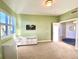 Home office bathed in natural light, featuring green walls, white desk, and hardwood floors in open doorway at 611 Riviera Dunes Way # 308, Palmetto, FL 34221