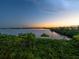 Picturesque view of bay at sunset, showcasing lush trees and a tranquil waterfront at 611 Riviera Dunes Way # 308, Palmetto, FL 34221