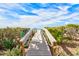 Beach access via a wooden walkway over lush vegetation at 2590 N Beach Rd # 3, Englewood, FL 34223