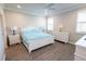 Main bedroom with white furniture, light blue bedding, and wood floors at 20676 Galileo Pl, Venice, FL 34293