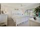 Bright bedroom featuring a white bed set, neutral carpet, and large windows offering ample natural light and outdoor views at 4706 Sand Trap Street E Cir # 202, Bradenton, FL 34203