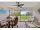 Enclosed lanai with tiled floor, ceiling fan, comfortable seating and serene backyard views at 4706 Sand Trap Street E Cir # 202, Bradenton, FL 34203