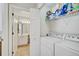 Functional laundry room with a washer and dryer, shelving, and an adjacent bathroom at 4706 Sand Trap Street E Cir # 202, Bradenton, FL 34203