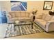 Comfortable living room showcasing plush sofas, a glass coffee table, and a beach-themed painting at 4706 Sand Trap Street E Cir # 202, Bradenton, FL 34203