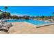 Community pool area featuring ample seating, lounge chairs, an outdoor bar, and views of the surrounding landscape at 4706 Sand Trap Street E Cir # 202, Bradenton, FL 34203