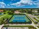 Aerial view of the blue and green community tennis courts surrounded by lush landscaping at 4706 Sand Trap Street E Cir # 202, Bradenton, FL 34203