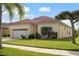 One-story house with tile roof, two-car garage, and landscaped yard at 5301 Laurel Oak Ct, North Port, FL 34287