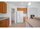 Kitchen with wood cabinets, white appliances and pantry at 5301 Laurel Oak Ct, North Port, FL 34287