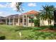 Single-story house exterior with a screened lanai and manicured lawn at 5301 Laurel Oak Ct, North Port, FL 34287