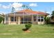 Rear view of single-story house with screened lanai and neat landscaping at 5301 Laurel Oak Ct, North Port, FL 34287