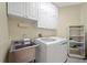 Laundry room with washer, dryer, shelving and sink at 5301 Laurel Oak Ct, North Port, FL 34287