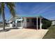 The mobile home features a large carport, mature landscaping, and painted trim at 4802 Brae Burn Ave, Sarasota, FL 34234