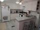 Cozy kitchen features white appliances, breakfast bar, and plenty of storage at 4802 Brae Burn Ave, Sarasota, FL 34234