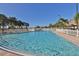 A swimming pool surrounded by trees and lounge chairs on a sunny day at 4802 Brae Burn Ave, Sarasota, FL 34234