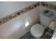 Cozy half-bath with seashell themed wallpaper and a toilet with tissue box at 4802 Brae Burn Ave, Sarasota, FL 34234