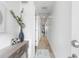Clean, bright hallway with white walls, light wood floors, and a console table at the entrance at 1709 N Tamiami Trl # 403, Sarasota, FL 34234