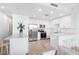 All-white kitchen features stainless steel appliances, quartz countertops, and modern bar stools at 1709 N Tamiami Trl # 403, Sarasota, FL 34234