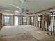 Spacious living room with exposed studs, original windows, ceiling fans, and plywood subfloors awaiting renovation at 3710 Gulf Of Mexico Dr # E3, Longboat Key, FL 34228