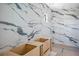 Modern bathroom design with unfinished wood cabinets and striking marble-patterned tiles on the walls at 3621 San Remo Ter, Sarasota, FL 34239
