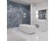 Beautiful bathroom features blue tiled wall shower, white free standing tub and white vanity at 3621 San Remo Ter, Sarasota, FL 34239
