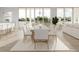 Bright dining room with large windows and a wooden table surrounded by white upholstered chairs at 3621 San Remo Ter, Sarasota, FL 34239