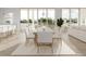 Bright dining area with a long table, seating for eight, light wood floors, and waterfront views at 3621 San Remo Ter, Sarasota, FL 34239