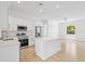 Open concept kitchen with island, stainless steel appliances, and light wood flooring at 23246 Stelling Ave, Port Charlotte, FL 33980