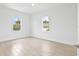 Bright bedroom with two windows, ceiling fan and wood-look tile floors at 23246 Stelling Ave, Port Charlotte, FL 33980