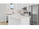 Modern kitchen with white cabinets, stainless steel appliances, and an island at 23246 Stelling Ave, Port Charlotte, FL 33980