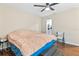Bedroom with brown comforter, hardwood floors, ceiling fan and open doorway to a bathroom at 301 Lambert St, Port Charlotte, FL 33948