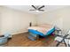 Bedroom with brown comforter, ceiling fan, hardwood floors, and access to a bathroom at 301 Lambert St, Port Charlotte, FL 33948