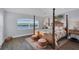 Main bedroom with a large four poster bed and water views at 1910 Oregon Trl, Englewood, FL 34224