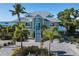 Two-story waterfront home with metal roof, paver driveway, and lush landscaping at 1910 Oregon Trl, Englewood, FL 34224