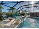 Relaxing pool area with covered patio, lounge chairs, and water feature at 1910 Oregon Trl, Englewood, FL 34224