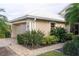 Tan house with white roof, double-car garage, and well-manicured landscaping at 326 Saint George Ct # 14, Venice, FL 34293
